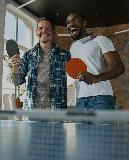  Two teammates playing table tennis and laughing